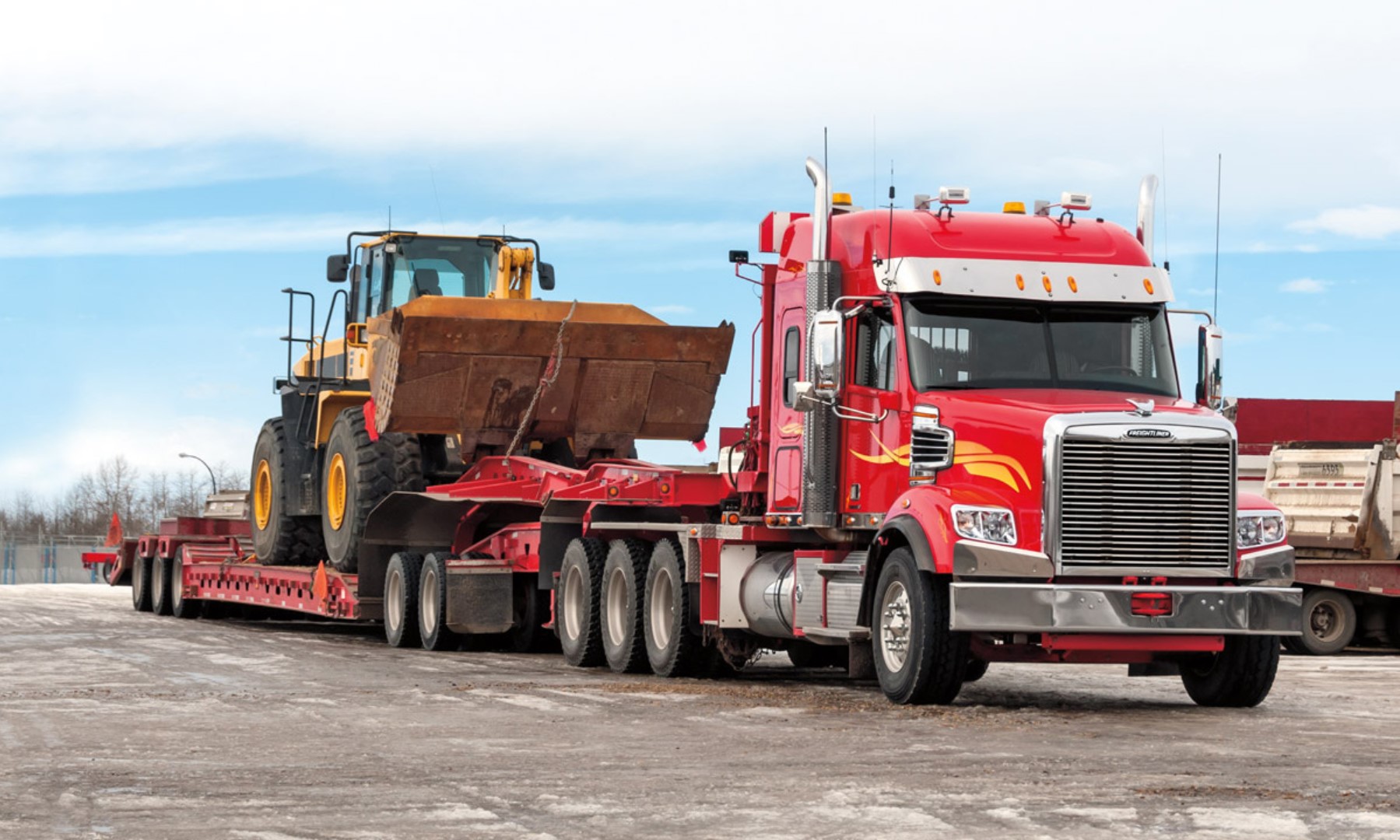 Heavy machinery being loaded onto a transport vehicle